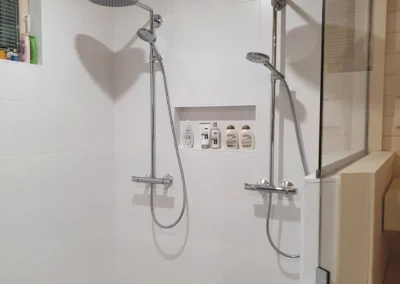 Kylpyhuoneen remontti kahdella suihkulla ja upotetulla pesuainehyllyllä