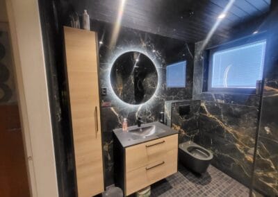 Kylpyhuoneremontti tummalla ilmeella, seinäasennettu wc-istuin